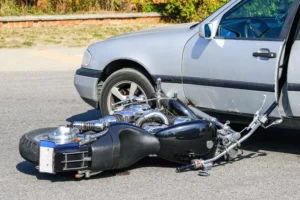 Damaged Motorcycle Lying On The Ground After A Collision With A Car, Illustrating One Of The Common Motorcycle Accident Injuries In Arlington.