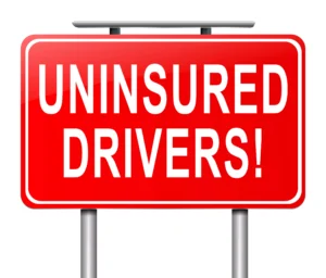 Red Road Sign With Bold White Letters Reading “Uninsured Drivers!” Representing Cases Managed By A Dallas Uninsured Motorist Lawyer.